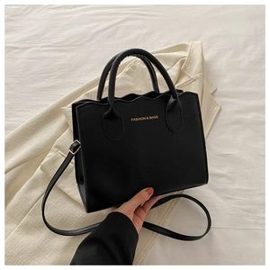 Detail of wavy edge trim and golden text print on black matte PU leather crossbody bag