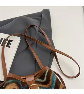 Detail of retro knit bucket bag showing textured pattern and adjustable leather strap