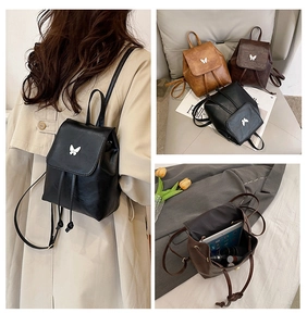 Detail showing vintage mini backpack textures, butterfly buckle, and internal storage space
