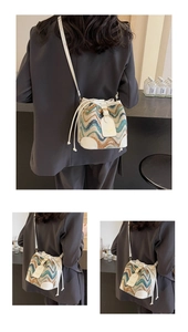 Detail of colorful wavy texture fabric and white leather trim on women's bucket bag