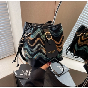 Close-up of bohemian bucket bag featuring wave-pattern woven fabric and black leather trim