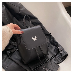 Close-up of black PU leather mini backpack with a delicate white butterfly ornament