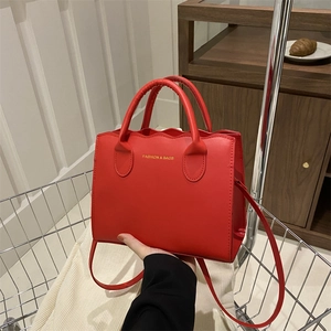 Chic red wavy edge tote bag with gold lettering in a casual shopping setting