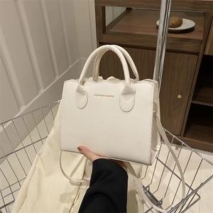 Chic cream-colored wavy edge tote bag with adjustable shoulder strap in metal basket