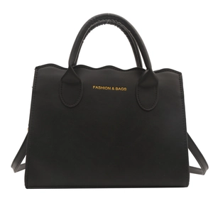 Chic black wavy edge tote bag with gold lettering and adjustable shoulder strap