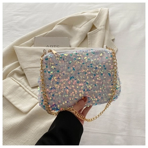 Close-up of shimmering iridescent sequins on a stylish crossbody bag with gold chain strap