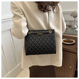 Détail du sac bandoulière matelassé noir avec chaîne dorée et motif à losanges chic