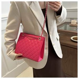 Détail du sac matelassé fuchsia avec chaîne dorée et inscription de la marque