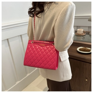 Détail du sac en cuir matelassé rose avec bandoulière chaîne dorée et logo en métal