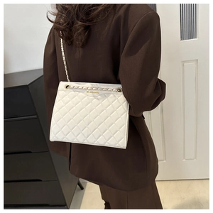 Détail du sac à chaîne en cuir matelassé blanc montrant les coutures et la dorure