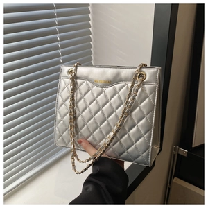 Détail du sac argenté matelassé avec surpiqûres en losanges et texture métallique
