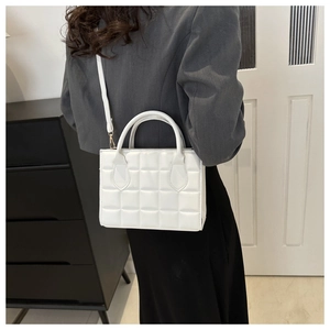 Minimalist white quilted square handbag shown on shoulder for daily fashion style