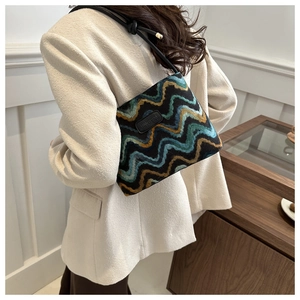 Detail of the zigzag knit pattern on a shoulder bag with a black leather logo patch