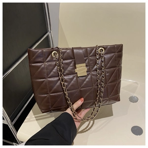 Close-up of brown quilted tote bag with gold chain strap and square metal buckle