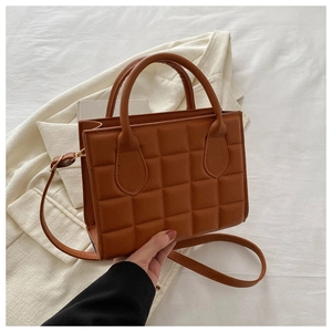 Detailed texture of caramel quilted faux leather handbag with checkerboard pattern