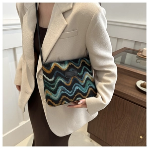 Detail of colorful wave pattern woven tote bag with leather logo tag and thin black strap