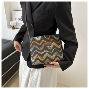 Detail of retro chevron textured crossbody bag with leather strap and logo patch