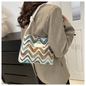 Detail showing zigzag woven shoulder bag with white rope strap and decorative knot