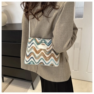 Detail of colorful woven shoulder bag with wavy pattern and JINGPIN leather label