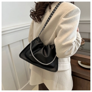 Detail of black pleated cloud bag with stylish chain strap and soft leather texture