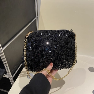 Elegant black sequin crossbody bag with gold chain strap shown in a hand-held view