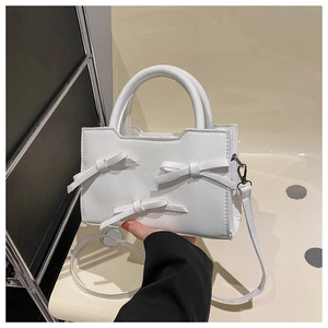 White PU leather handbag with decorative bows and a detachable shoulder strap