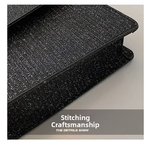 Detail shot of black glitter fabric showing precision stitching and premium leather trim