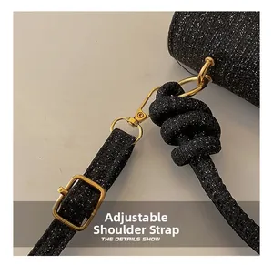 Detail of glitter fabric texture and adjustable gold-tone buckle on black shoulder bag