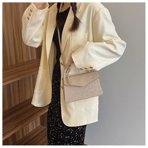 Detail of champagne gold glitter crossbody bag with woven strap and metallic finish