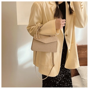 Detail view of champagne gold sequin handbag with knot handle and long shoulder strap