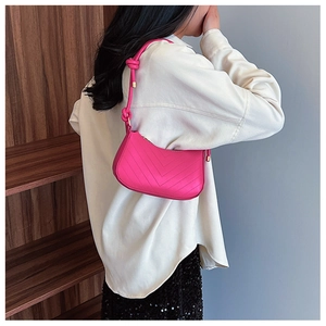 Dettaglio borsa a spalla in pelle rosso rosa con cuciture chevron e tracolla annodata