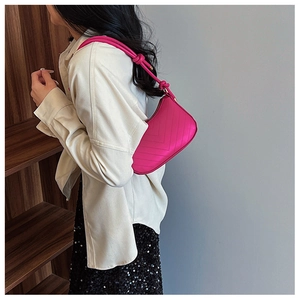 Dettaglio borsa sottospalla rosa con cuciture a V e tracolla con nodo decorativo moda
