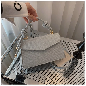 Close-up of a silver glitter evening handbag with a unique thick rope knot handle