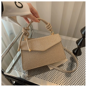 Close-up of champagne gold glitter handbag with envelope flap and metallic hardware