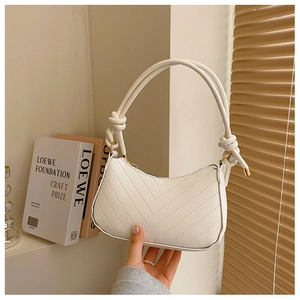 Dettaglio borsa hobo trapuntata bianca con un design a nodo unico sulla tracolla a spalla