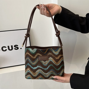 Fashionable knitted wave pattern tote bag with leather straps and knotted accents