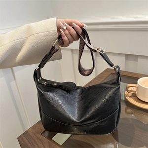 Retro black leather shoulder bag with wide geometric strap and golden logo detail