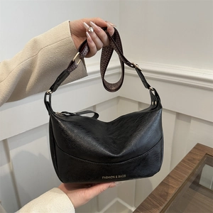 Retro black leather crescent crossbody bag with wide patterned strap and gold hardware
