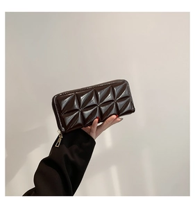 Détail d'un portefeuille marron foncé à relief 3D géométrique avec finition brillante vernie