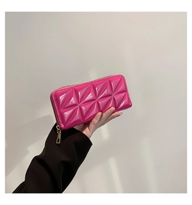 Détail d'un portefeuille rose vif à motif géométrique 3D et fermeture dorée