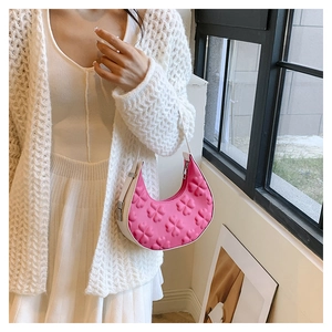 Detail of pink half-moon shoulder bag with 3D floral clover patterns and white leather strap