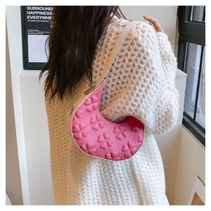 Pink crescent shoulder bag featuring 3D floral embossing and chic contrast strap details