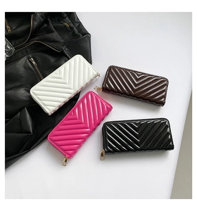 Flat lay of V-quilted patent leather wallets in multiple colors with gold zipper hardware