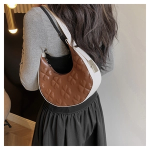 Detail of crescent shoulder bag with brown clover embossed leather and white trim