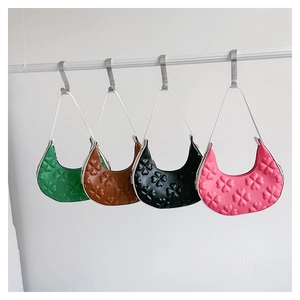Detailed view of four colorful clover-embossed crescent underarm bags on display