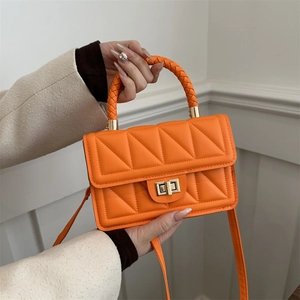 Vibrant orange quilted handbag with woven handles and a gold twist-lock closure