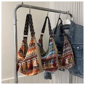 Detalle de bolsos de lona bohemios con borlas de colores y correas estampadas