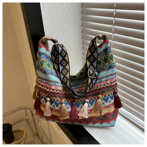 Détail d'un grand sac cabas bohème avec glands colorés et bandoulière géométrique tissée