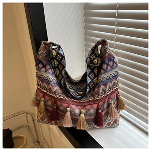 Détail du sac cabas bohème tissé avec des glands colorés et une bandoulière à motifs