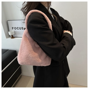 Close-up of pink faux fur tote bag carried by model wearing a black blazer jacket